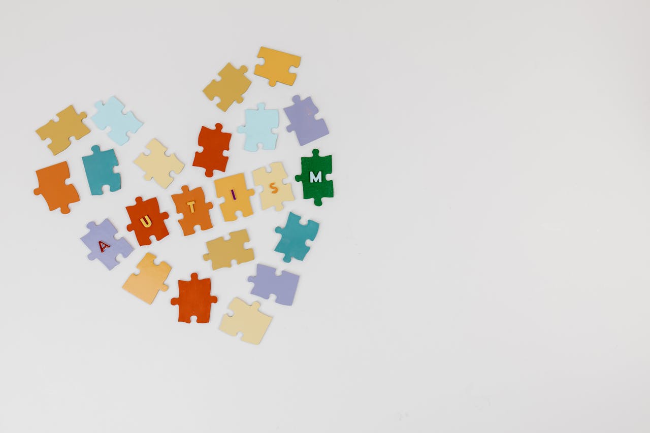 digital Colorful puzzle pieces arranged in a heart shape emphasizing Autism awareness on a white background.